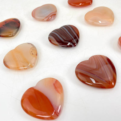 angled view of carnelian polished hearts for thickness