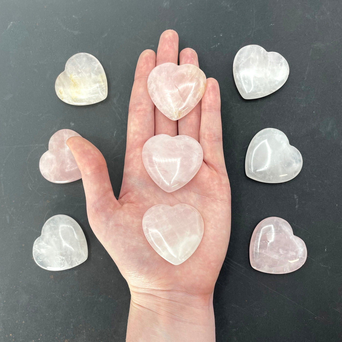 three rise quartz polished hearts in hand for size reference