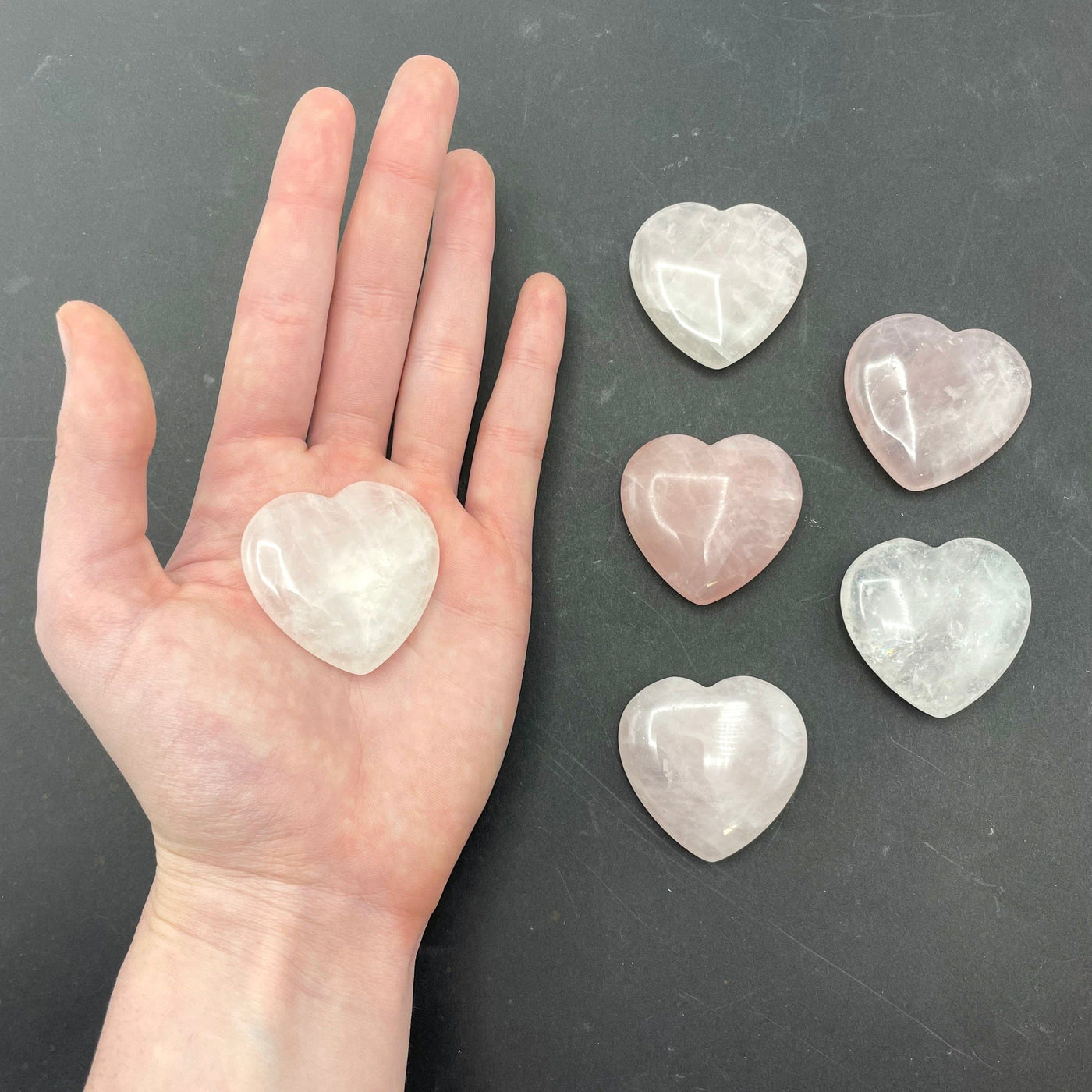 one rose quartz polished heart in hand for size reference