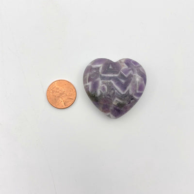 close up of chevron amethyst polished heart with penny for size reference