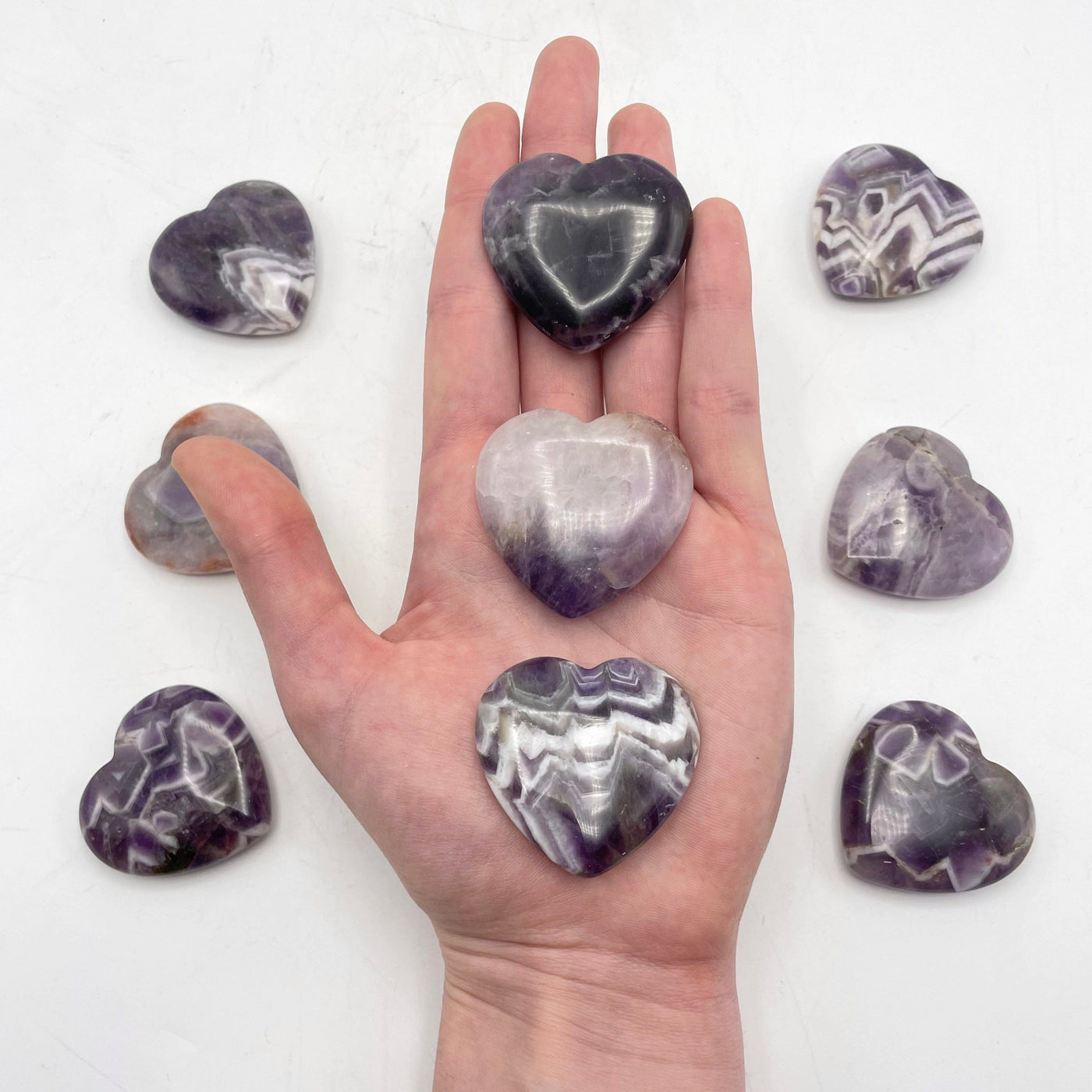 three chevron amethyst polished hearts in hand for size reference