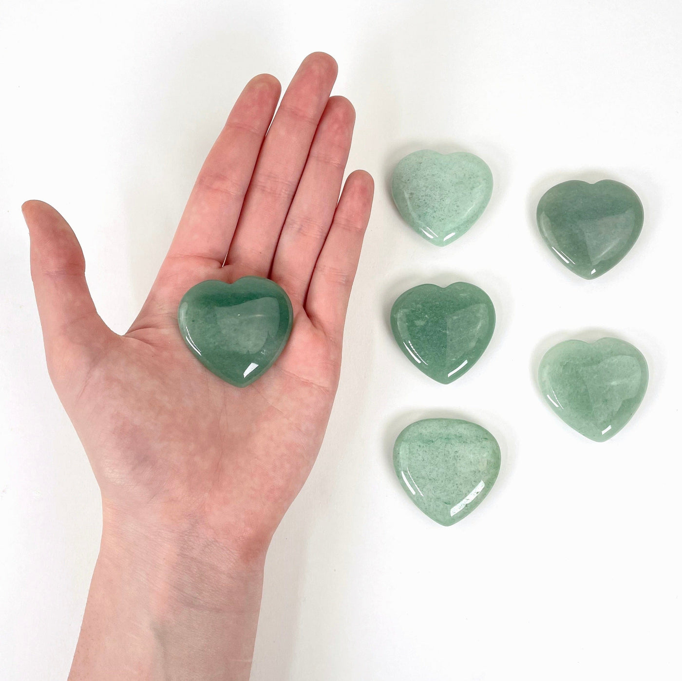 one green aventurine polished heart in hand for size reference