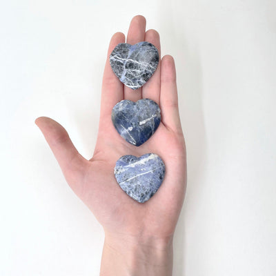 sodalite polished hearts in hand for size reference and possible damages