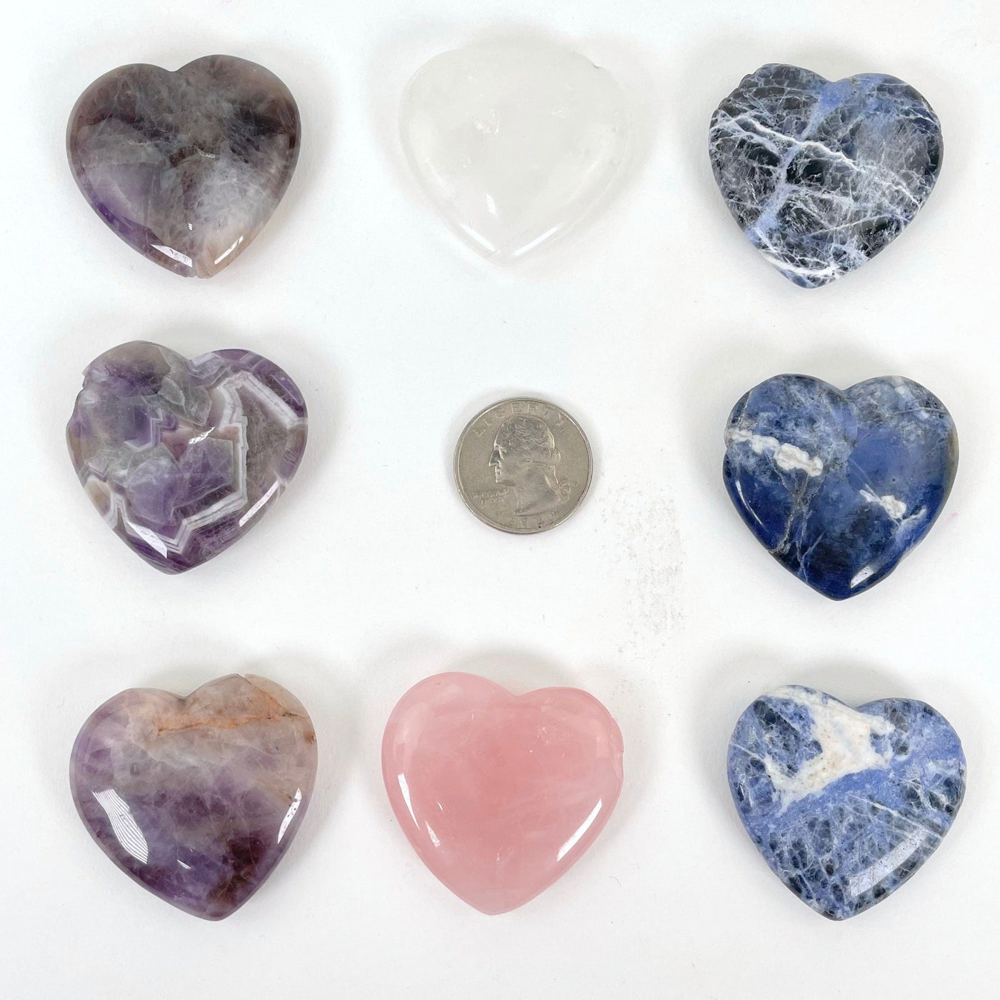 all polished heart stone options laying flat with quarter for size reference