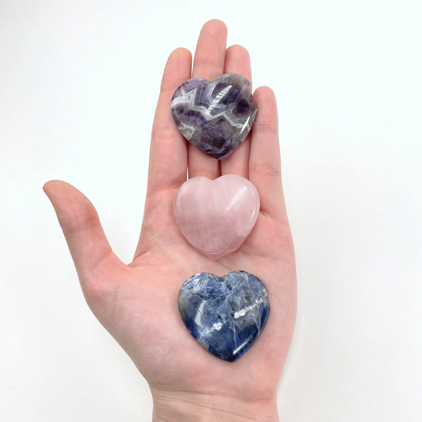 all three polished heart stone options in hand for size reference