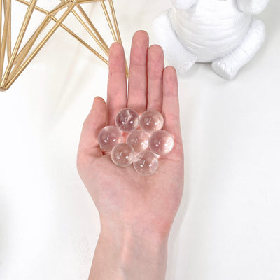 crystal quartz spheres in hand for size reference