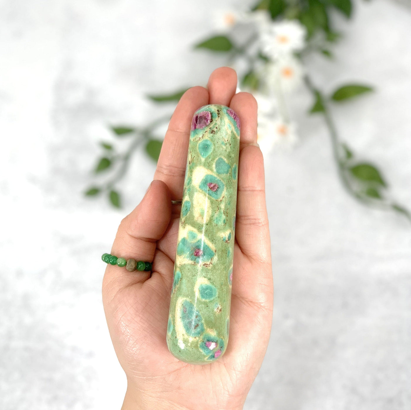 Hand holding the Ruby Fuchsite massage wand