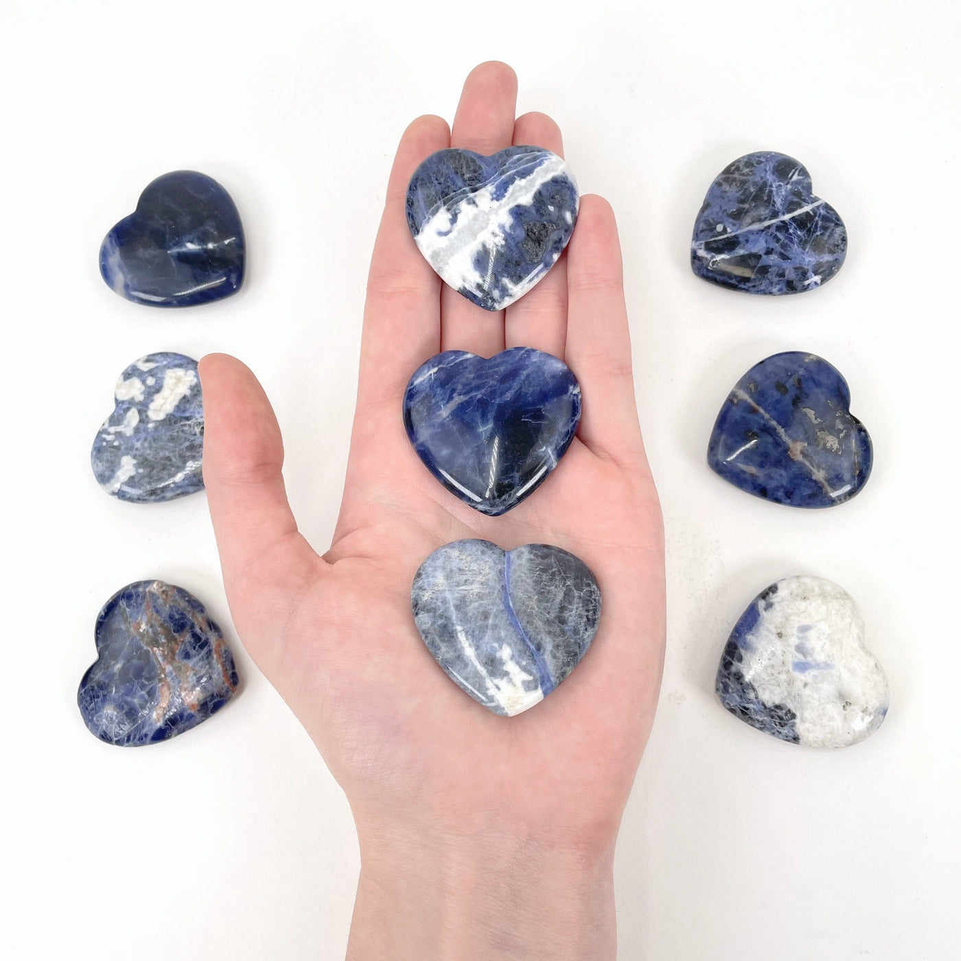 sodalite polished hearts in hand for size reference