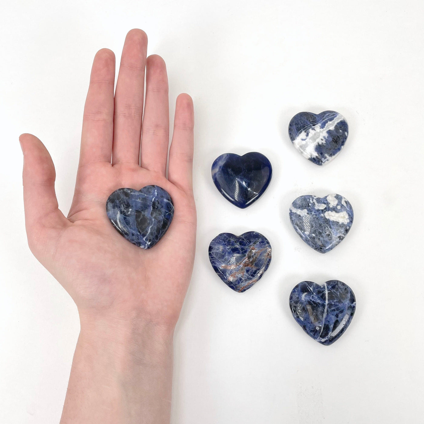 one sodalite polished heart in hand for size reference