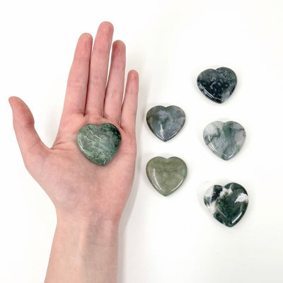 moss agate polished heart in hand for size reference