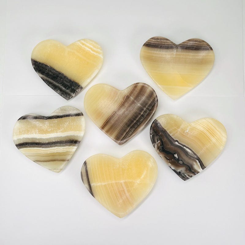 assorted mexican onyx heart bowls on a white background.