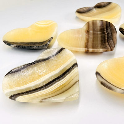 close up of assorted mexican onyx heart bowls on a white background.