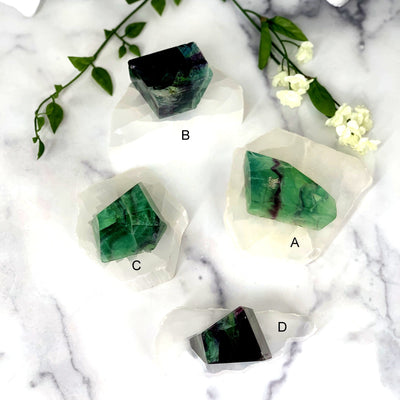 4 Beautiful Fluorite Chunks spread out on white background displaying options A B C D