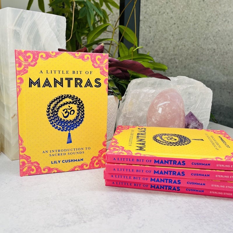 5 books laid out so you can see front cover which is yellow and pink with an OM symbol and necklace.