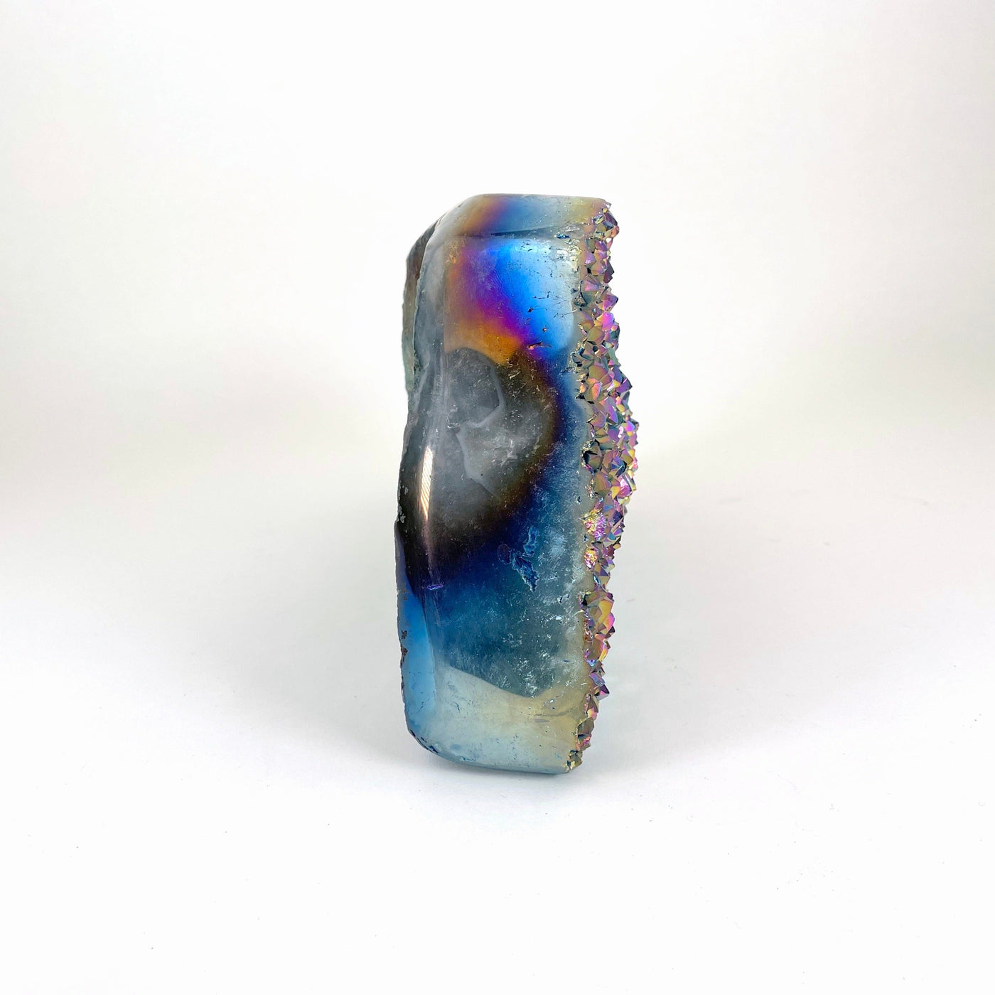 side view of rainbow titanium druzy stone propped up for thickness