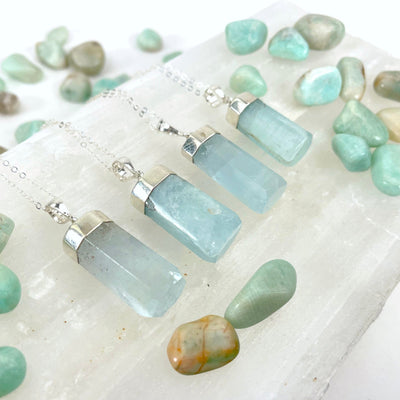 aquamarine pendant necklaces laying on display