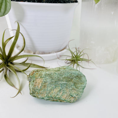 Fuchsite Free Form with decorations in the background