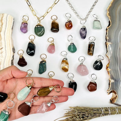 multiple tumbled stone pendants with silver and gold electroplated hoop bail pendants in hand for size reference 