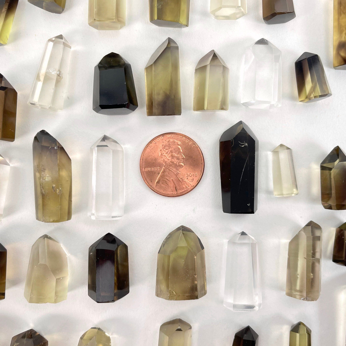 Natural Citrine Points on a white background with a penny for sizing.  They are mostly larger than the penny