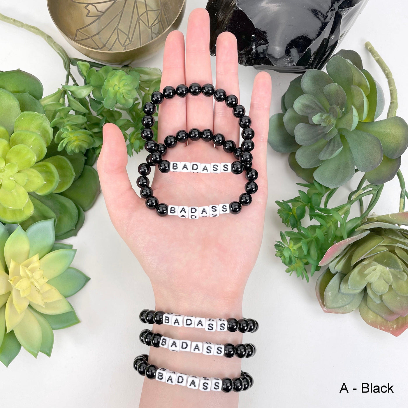 black "BADASS" letter bead option in hand and on wrist for color reference