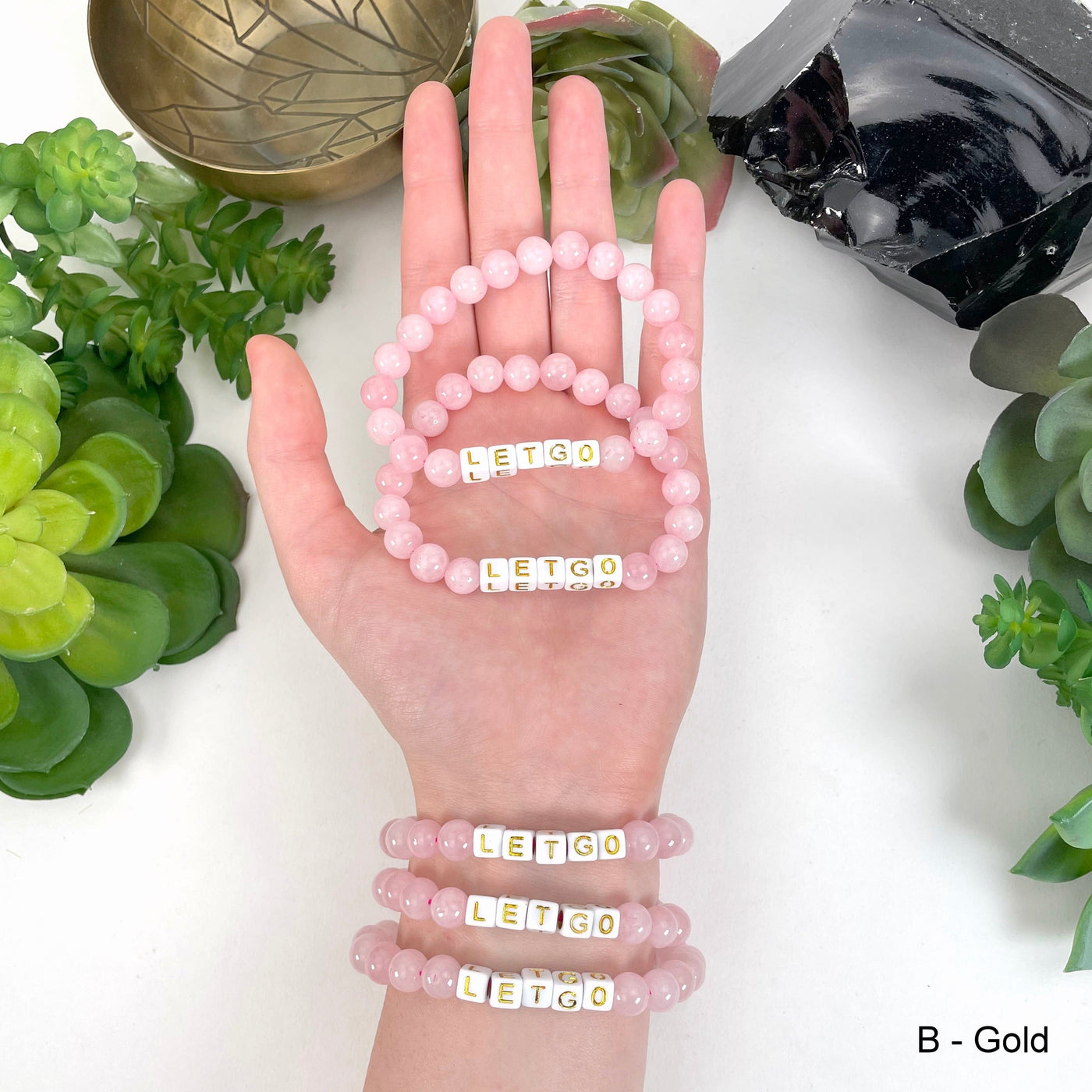 gold "LETGO" letter bead option in hand and on wrist for color reference