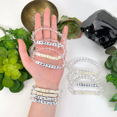 crystal quartz beaded bracelets in hand and on wrist with display