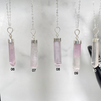 close up of pink kunzite necklace options 06 - 10 hanging on display