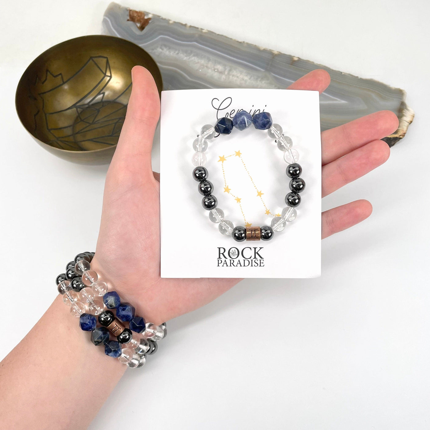 packaged gemini zodiac bracelet in hand with gemini zodiac bracelets on wrist