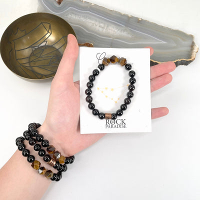 packaged capricorn zodiac bracelet in hand with capricorn zodiac bracelets on wrist