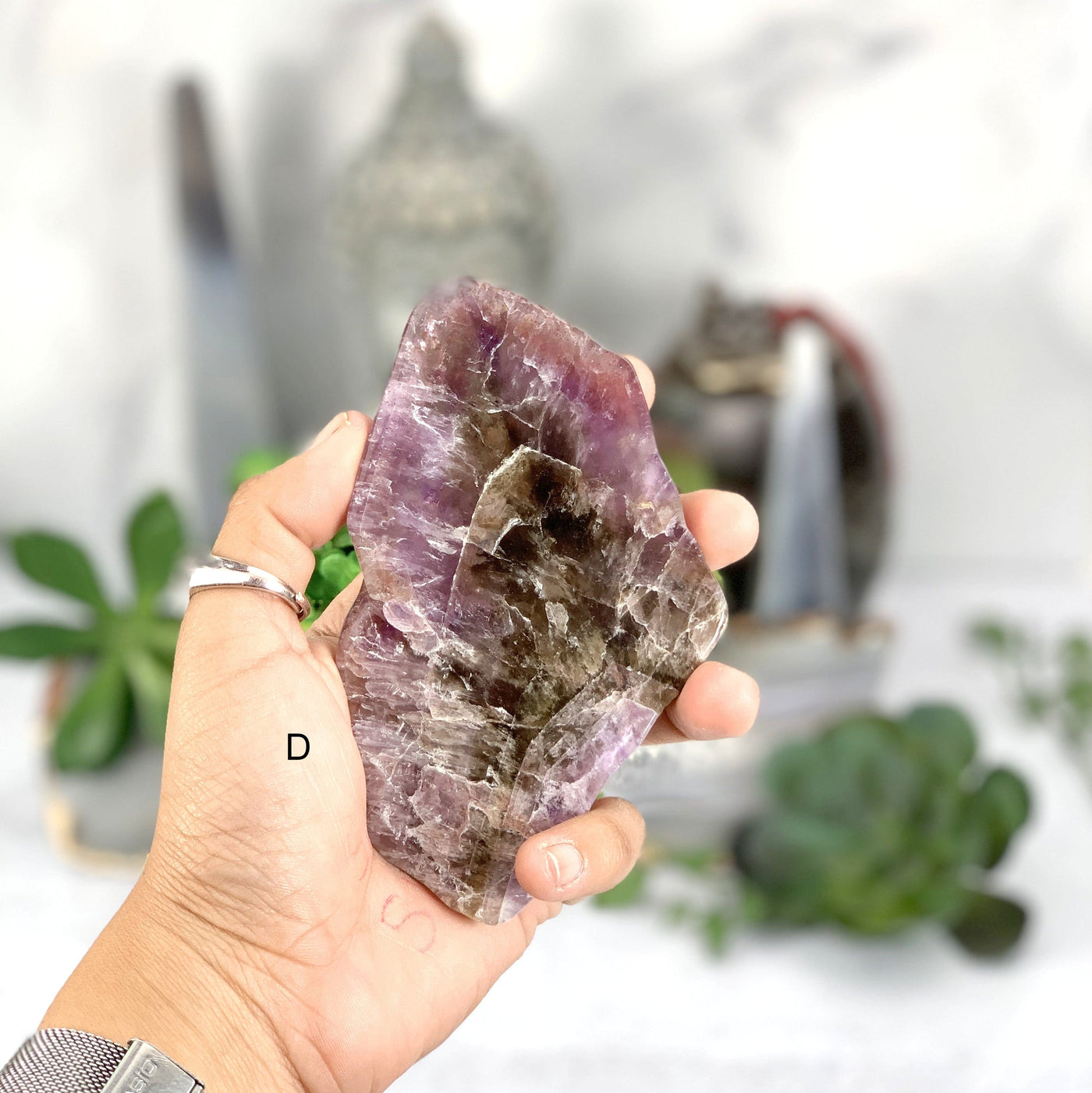 (D) Hand holding the purple Seven Mineral Slab 