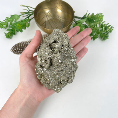 rough pyrite stone in hand for size reference
