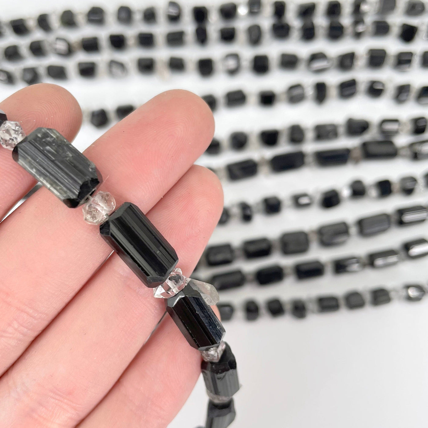 close up of black tourmaline with herkimer necklace in hand for size reference and details