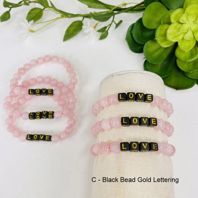 rose quartz bead bracelet with gold letters spelling LOVE