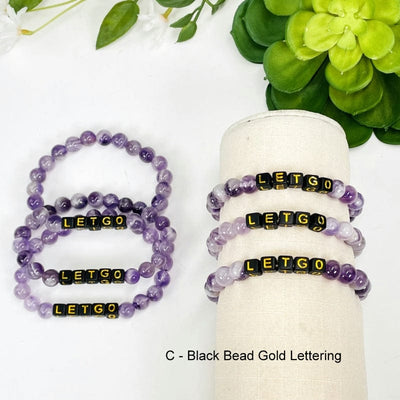 amethyst bead bracelet with black square beads that spell out LETGO in gold 
