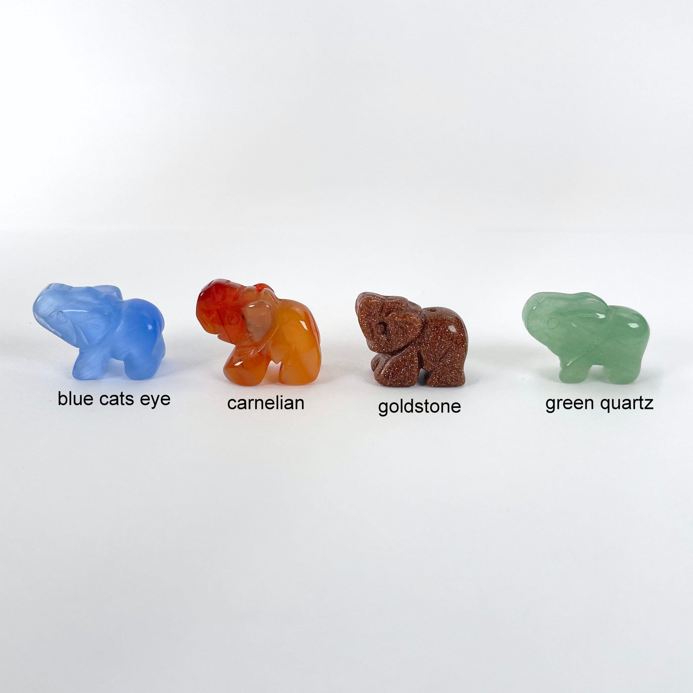 close up of blue cats eye, carnelian, goldstone, and green quartz gemstone elephant option
