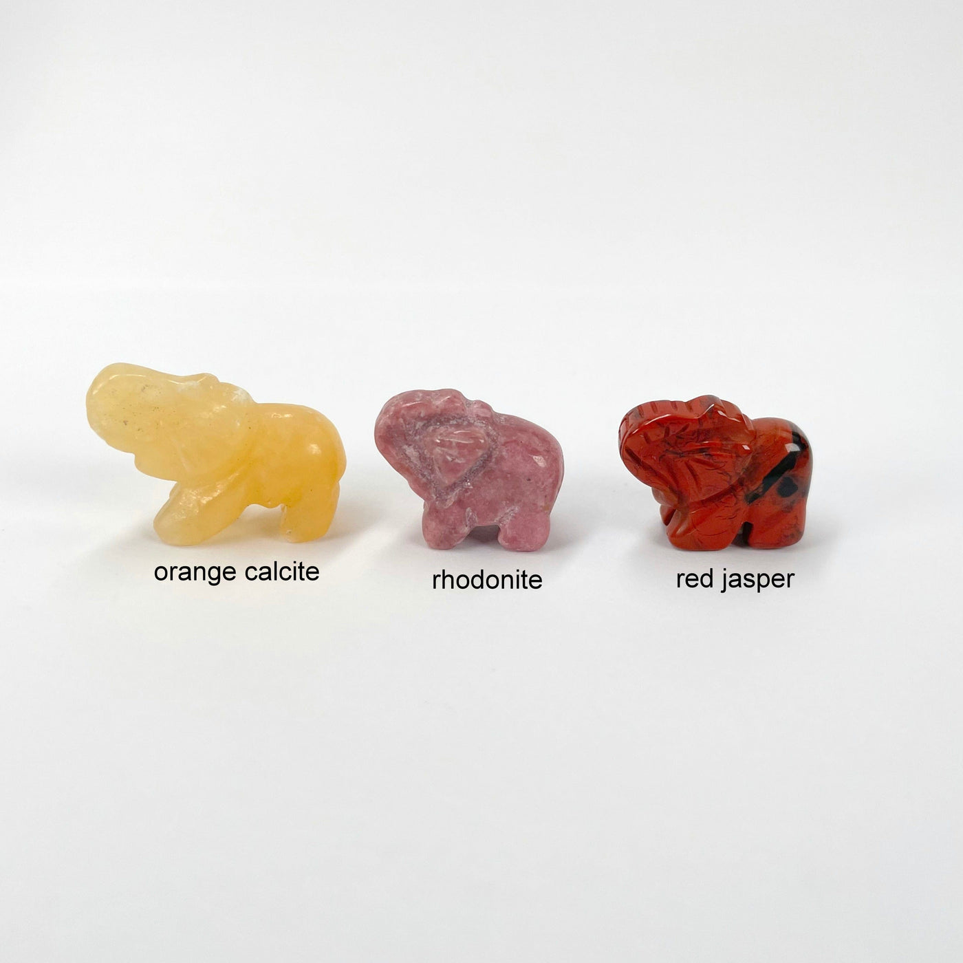 close up of orange calcite, rhodonite, and red jasper gemstone elephants