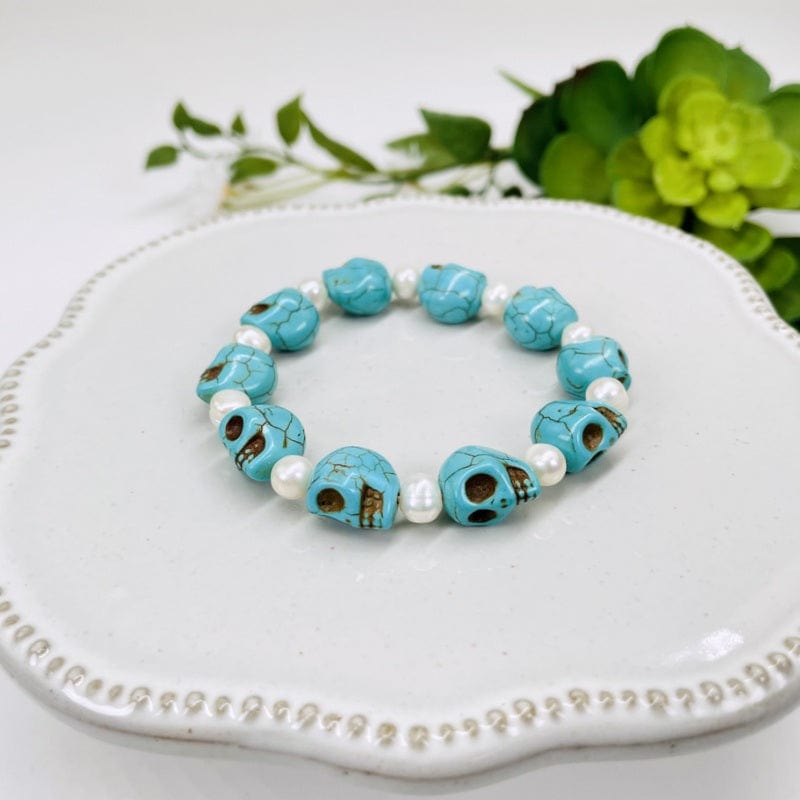 close up of the turquoise magnesite skull bead bracelets with pearl accents
