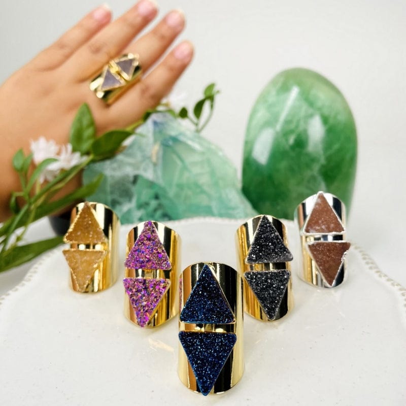 multiple double triangle druzy cigar band rings displayed to show the differences in the colors available 