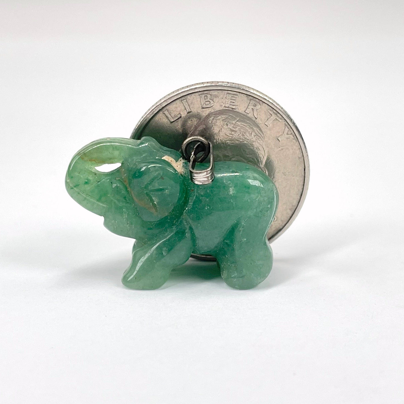 close up of green quartz elephant pendants with quarter for size reference
