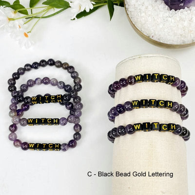 amethyst bead bracelet with black beads that say WITCH on it in gold letters 