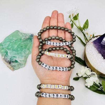 pyrite round bead bracelets that spell our BOSSBABE in hand for size reference 
