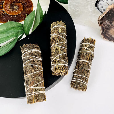 3 mugwort smudge bundles with decorations in the backgorund
