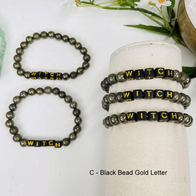 pyrite round bead bracelets with black square beads that spell out WITCH in gold