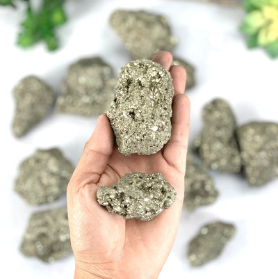 Hand holding the two piece sets of the pyrite clusters
