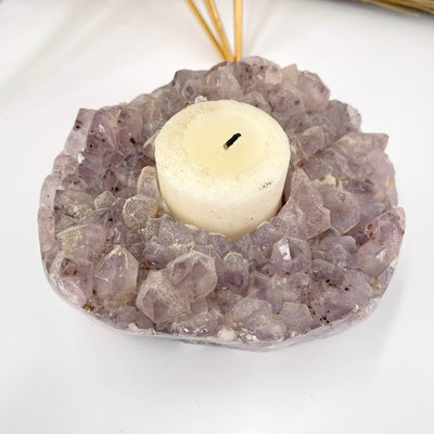 close up of amethyst cluster candle holder with candle
