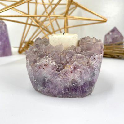 side view of amethyst cluster candle holder with candle for thickness