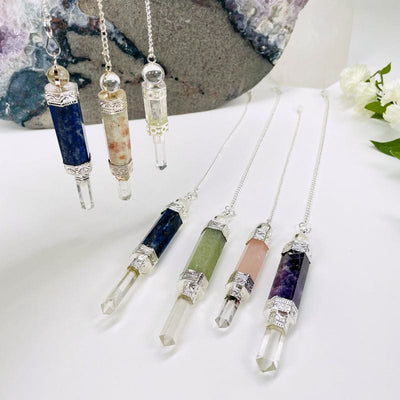 multiple crystal quartz point pendulums displayed to show the differences in the stones 