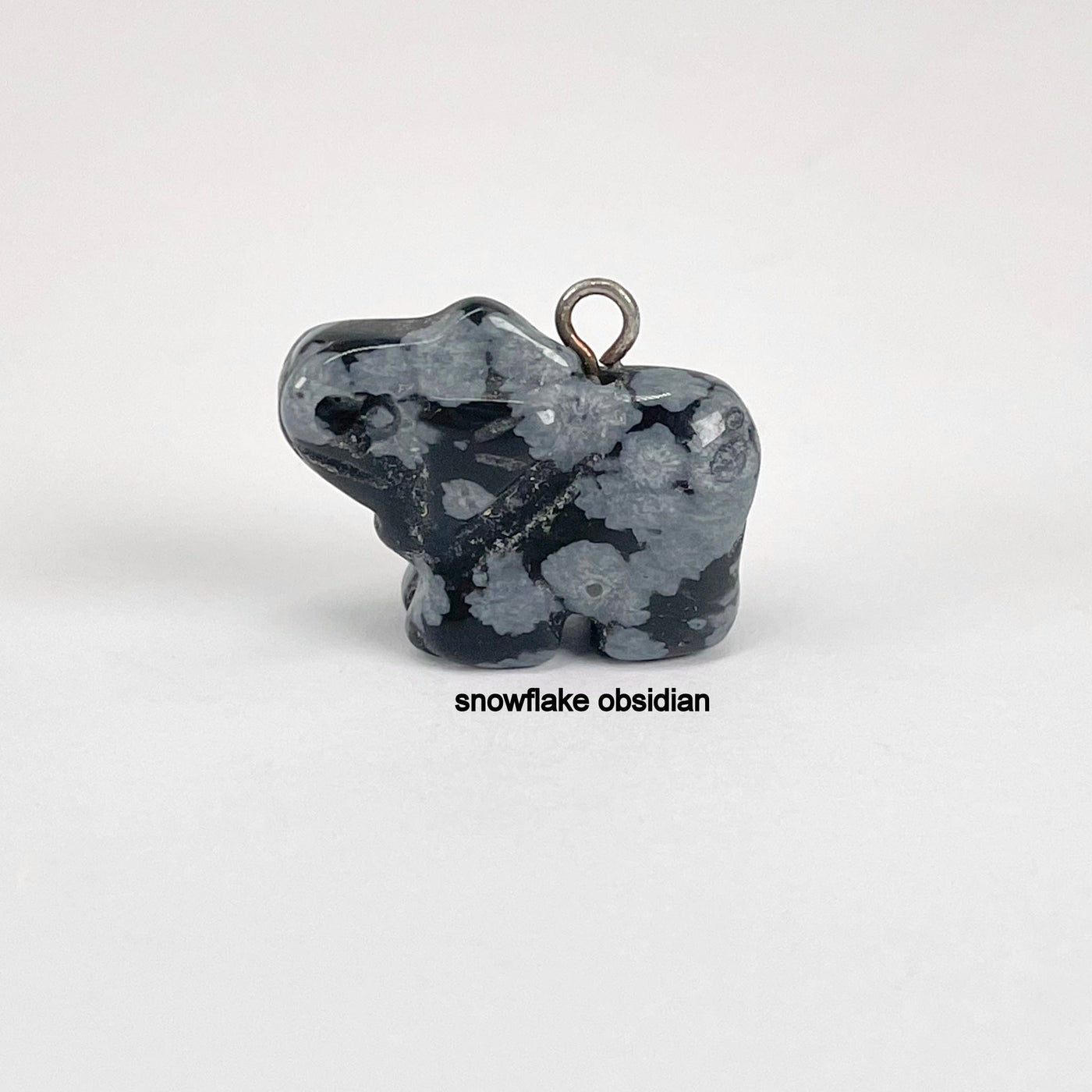 close up of snowflake obsidian elephant pendant for details