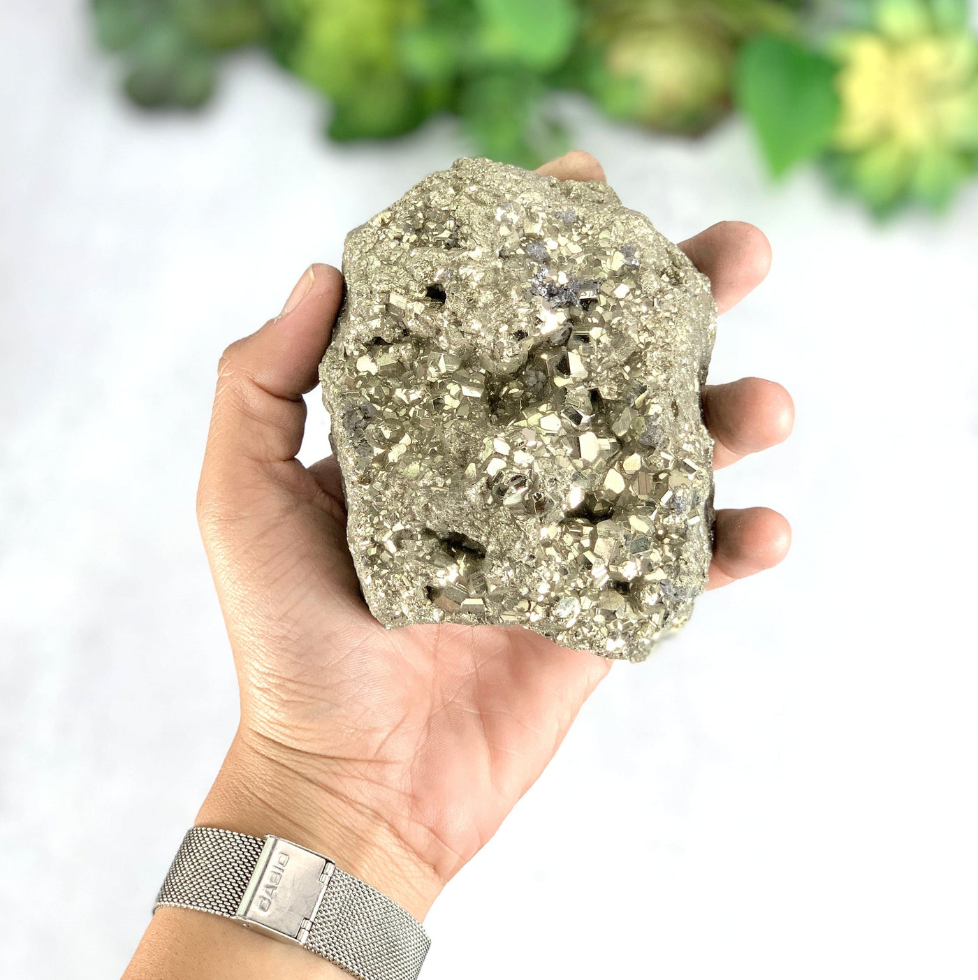 Hand holding the frontside of the Cluster Pyrite