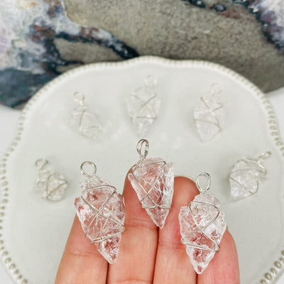 crystal quartz arrowhead wire wrapped charms in hand for size reference 